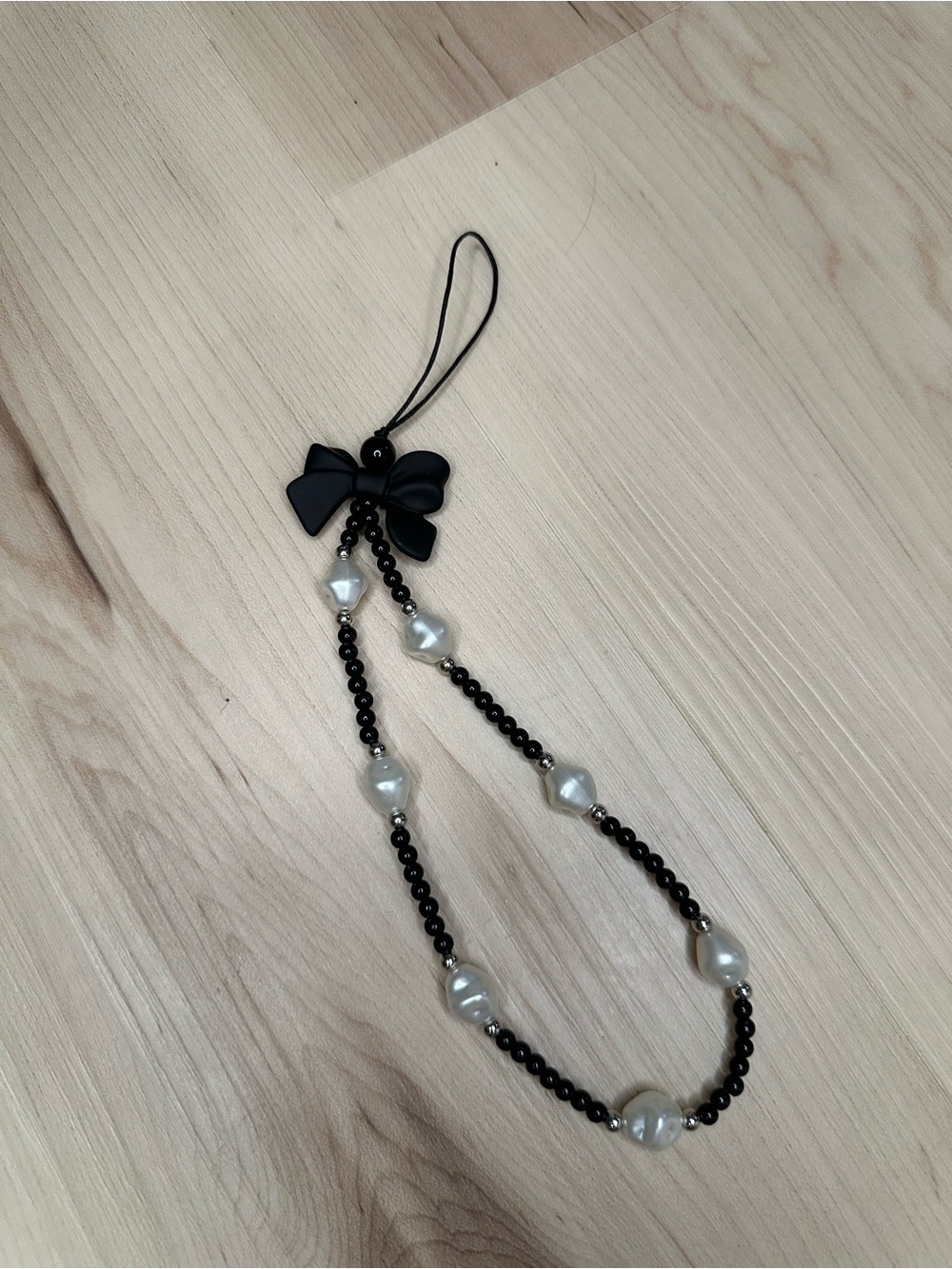 Black bow and faux pearl phone lanyard.
